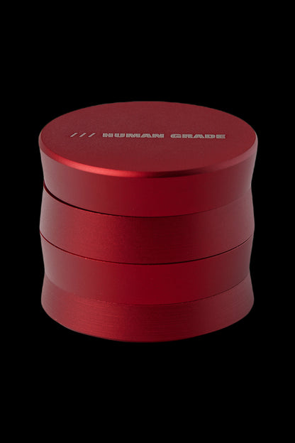Red four-piece cannabis grinder with "HUMAN GRADE" engraved on top.