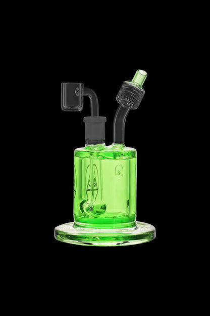 Green glass dab rig with accessories against a black background.
