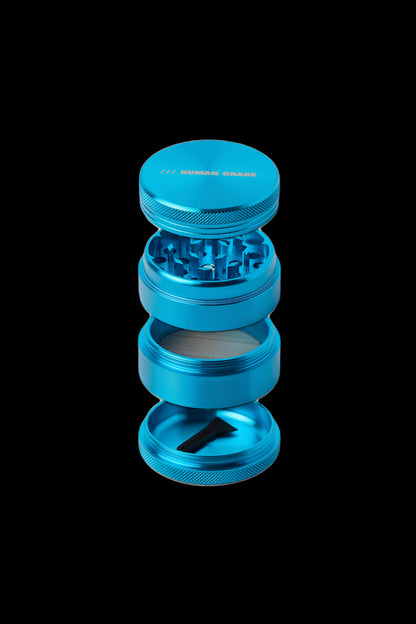 Blue four-piece cannabis grinder against a black background.