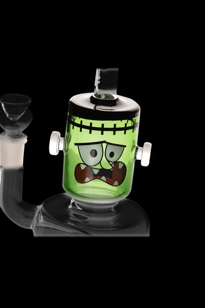Green glass water pipe shaped like Frankenstein's monster.