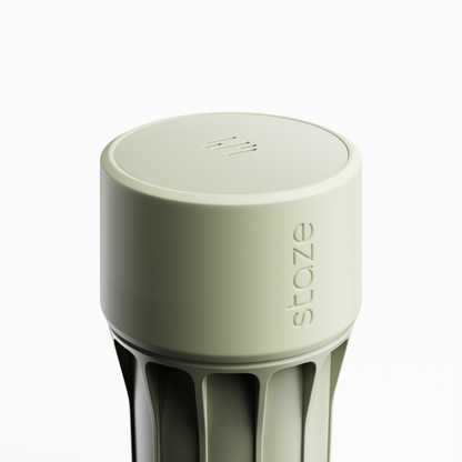 Close-up, slightly overhead view of the pale green STAZE PRESERVE showing its rounded top with vent slits and embossed side logo.