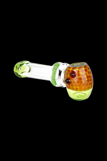 Green and orange glass pipe isolated on a black background.