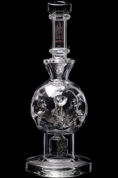 Clear glass water pipe with sculpted skull inside spherical chamber, studio shot.