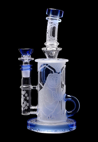 Frosted glass water pipe with blue accents and intricate character etchings.
