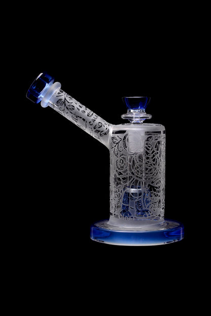 Intricate glass water pipe (bong) with floral cutouts and blue accents, isolated on a black background.