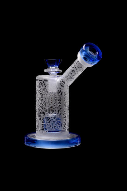 Glass water pipe with intricate floral latticework and blue accents, isolated on a black background.