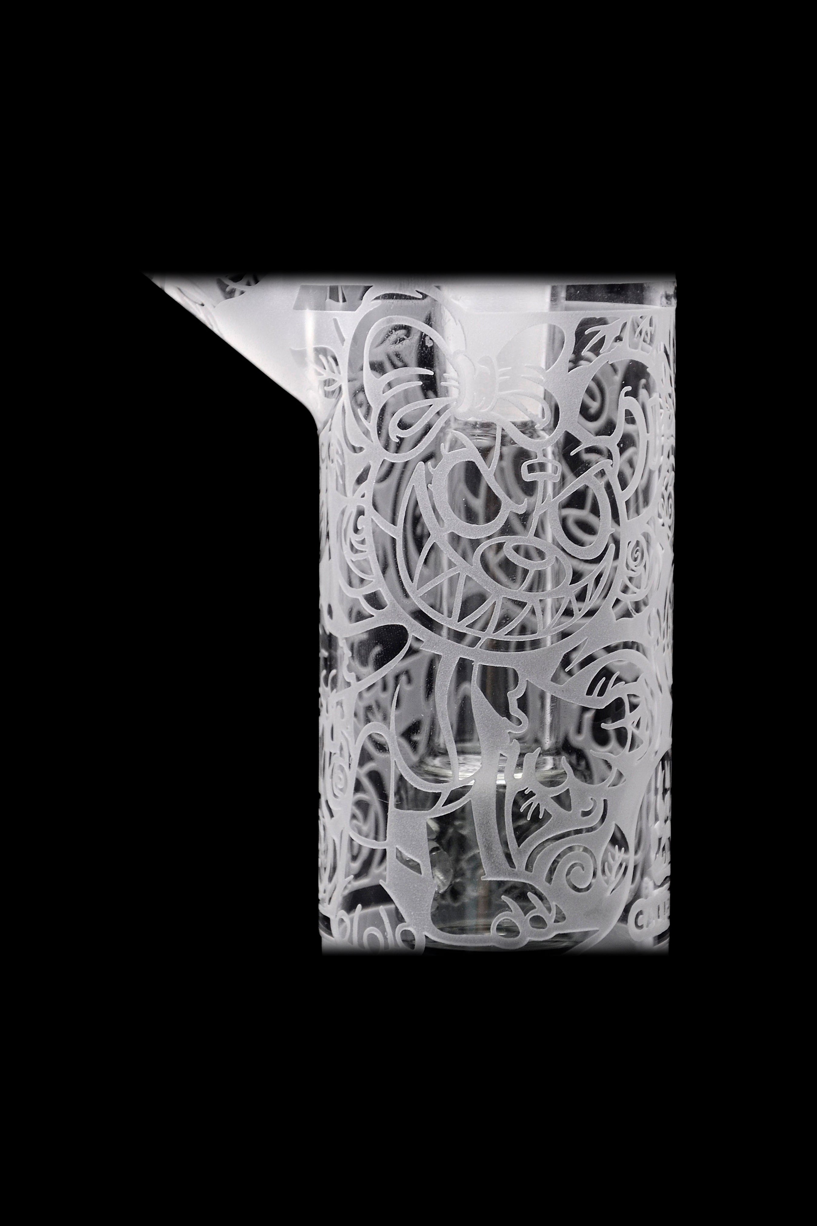 Intricate glass cannabis oil burner pipe with detailed floral etching.