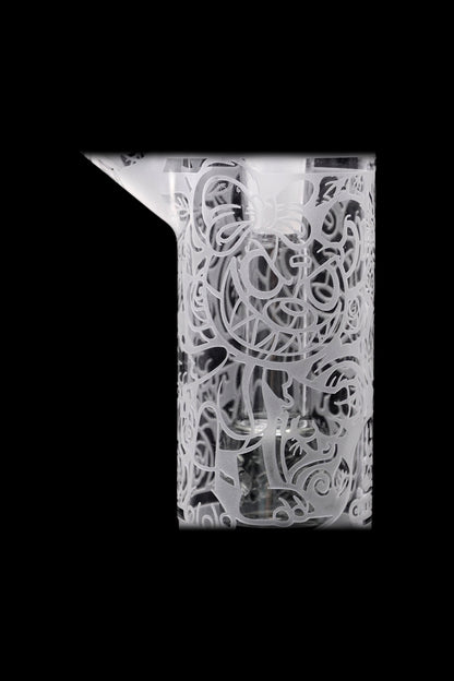 Intricate glass cannabis oil burner pipe with detailed floral etching.