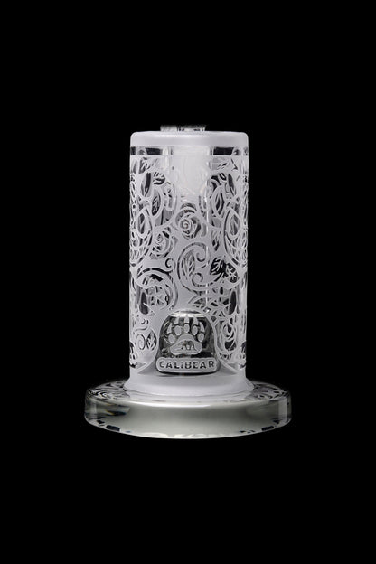 Clear glass bubbler with ornate floral carving and “Calibear” logo, isolated on a black background.
