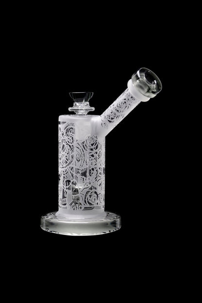 Frosted glass water pipe with intricate floral carvings, isolated on a black background.