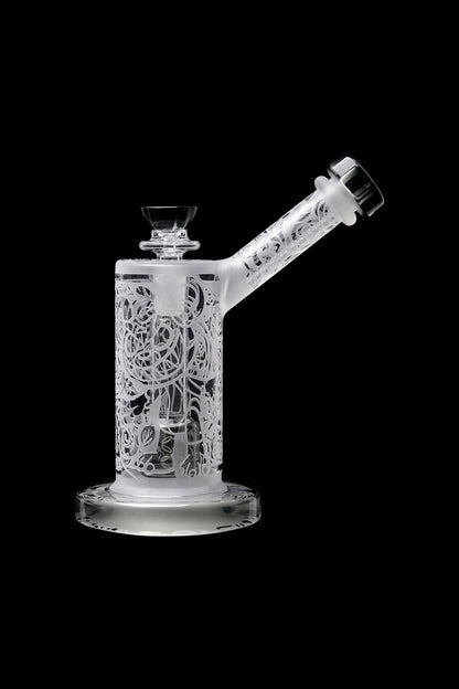 Frosted glass water pipe with intricate laser-cut designs, isolated on black.