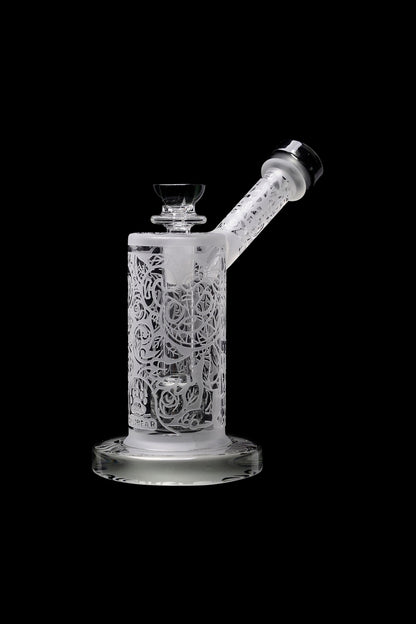 Intricate glass water pipe (rig) with floral lattice design, isolated on a black background.