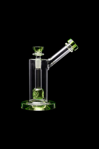 Green and clear glass water pipe (bong) against a black background.