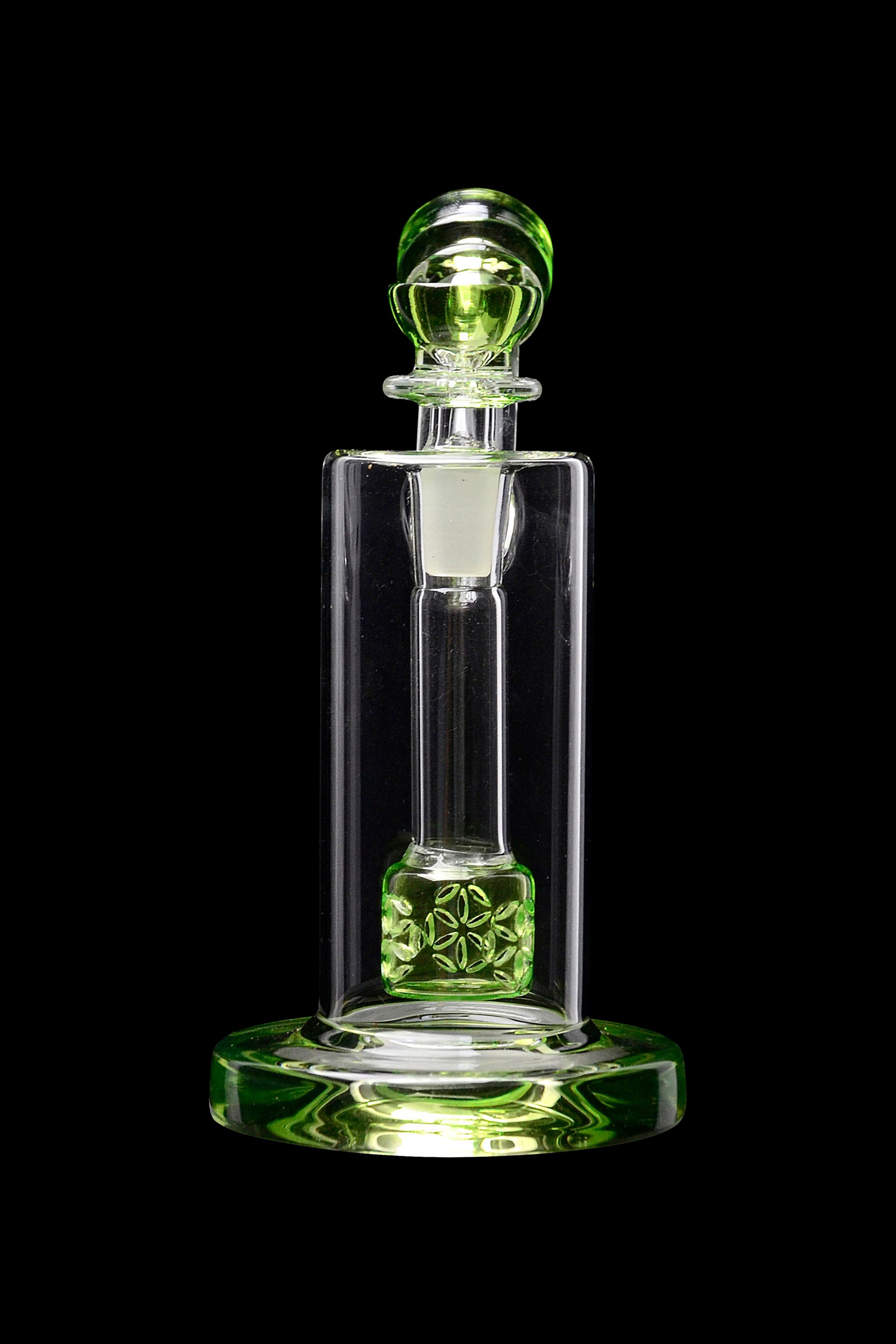Green glass dab rig with botanical details, isolated on a black background.