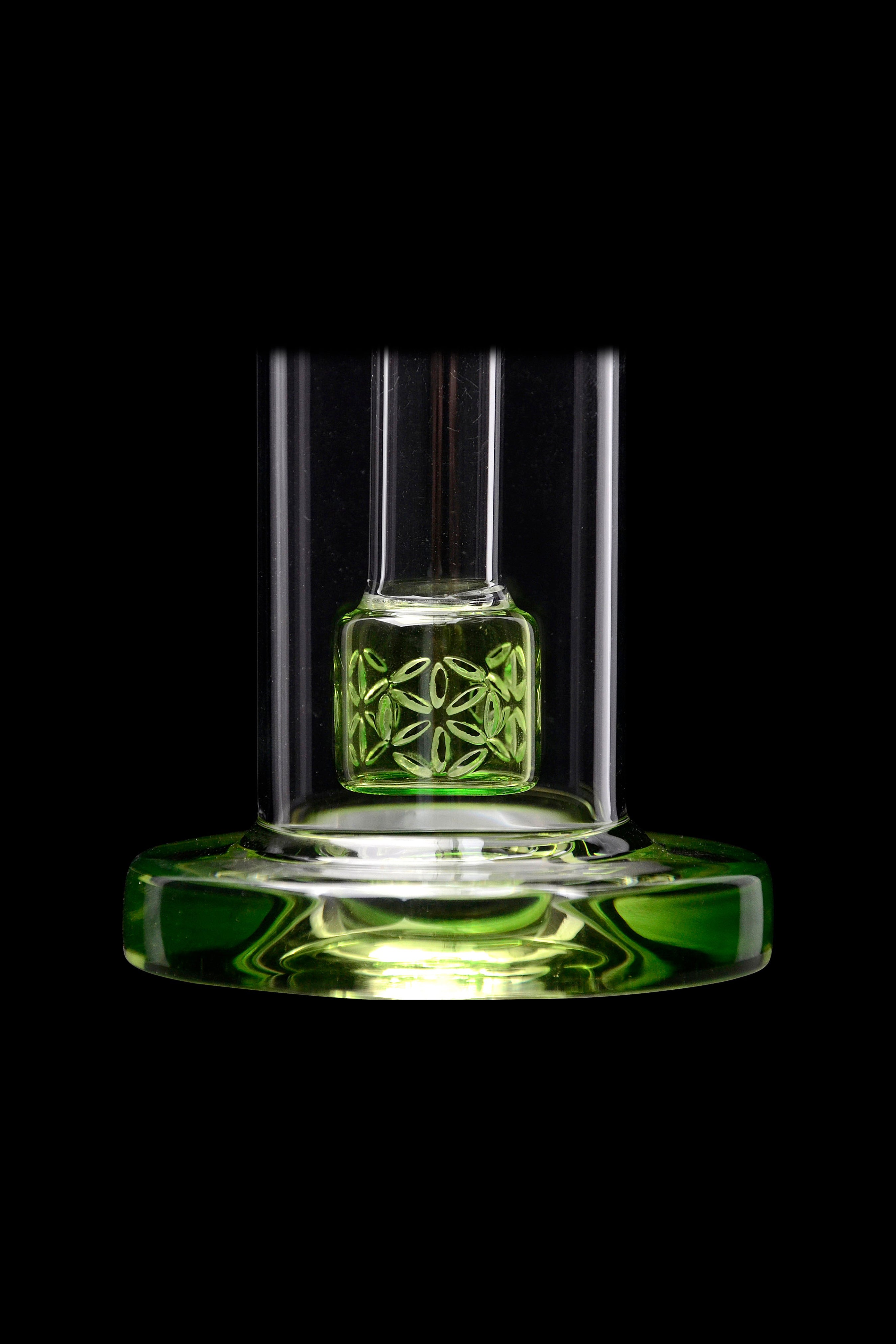 Green glass cannabis rig with intricate floral percolator, isolated on black.