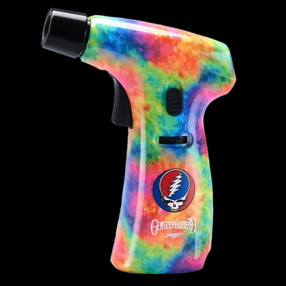 Close-up side view of a tie-dye patterned Grateful Dead Power Torch against a black background, showing its trigger, mode switch, and skull/lightning logo.