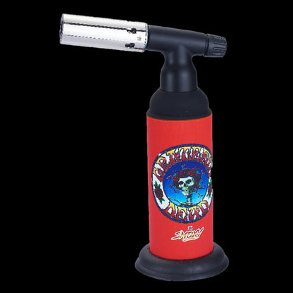 Close-up of the Grateful Dead Dragon Torch showing a red body with band skull artwork and a black angled nozzle against black.