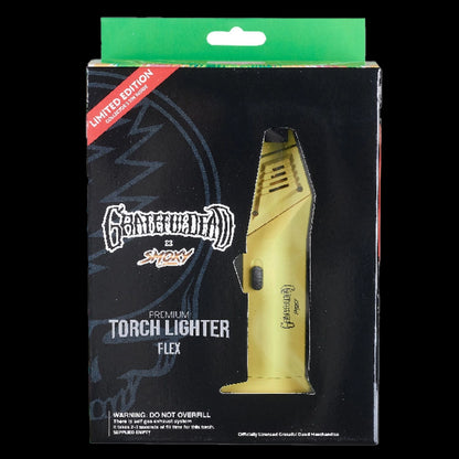Angled close-up of the yellow Grateful Dead Flex Torch visible through its black retail window packaging.