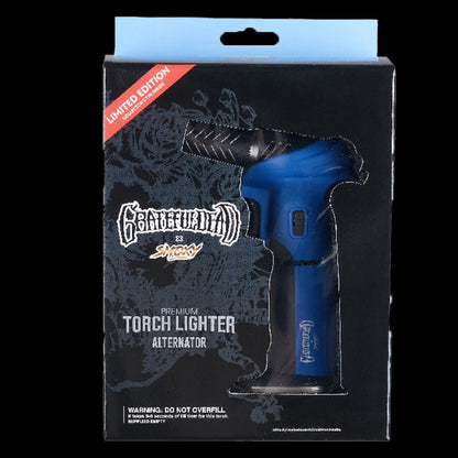 Front-facing packaged view of the Grateful Dead Alternator Torch showing a blue torch handle visible through a die-cut window against black floral-patterned packaging.