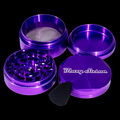 Top-down view of the metallic purple Blazy Susan 4-pc 3 Chamber Grinder with its four threaded components fanned open on a black background.
