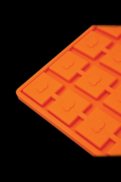Orange silicone ice cube tray with cannabis leaf-shaped molds.