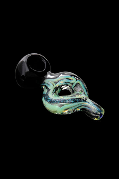 Hand-blown glass oil rig with iridescent green and blue swirls, isolated on black.
