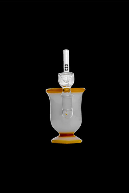 Elegant glass bubbler with orange accents and a clear mouthpiece, isolated on a black background.