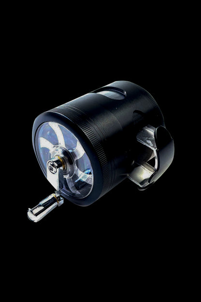 Black cannabis grinder with transparent chambers, showcasing ground herb.