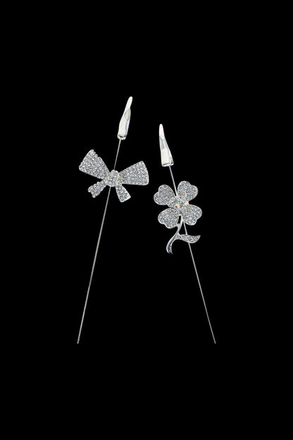 Diamond cannabis flower and bud earrings on black background.