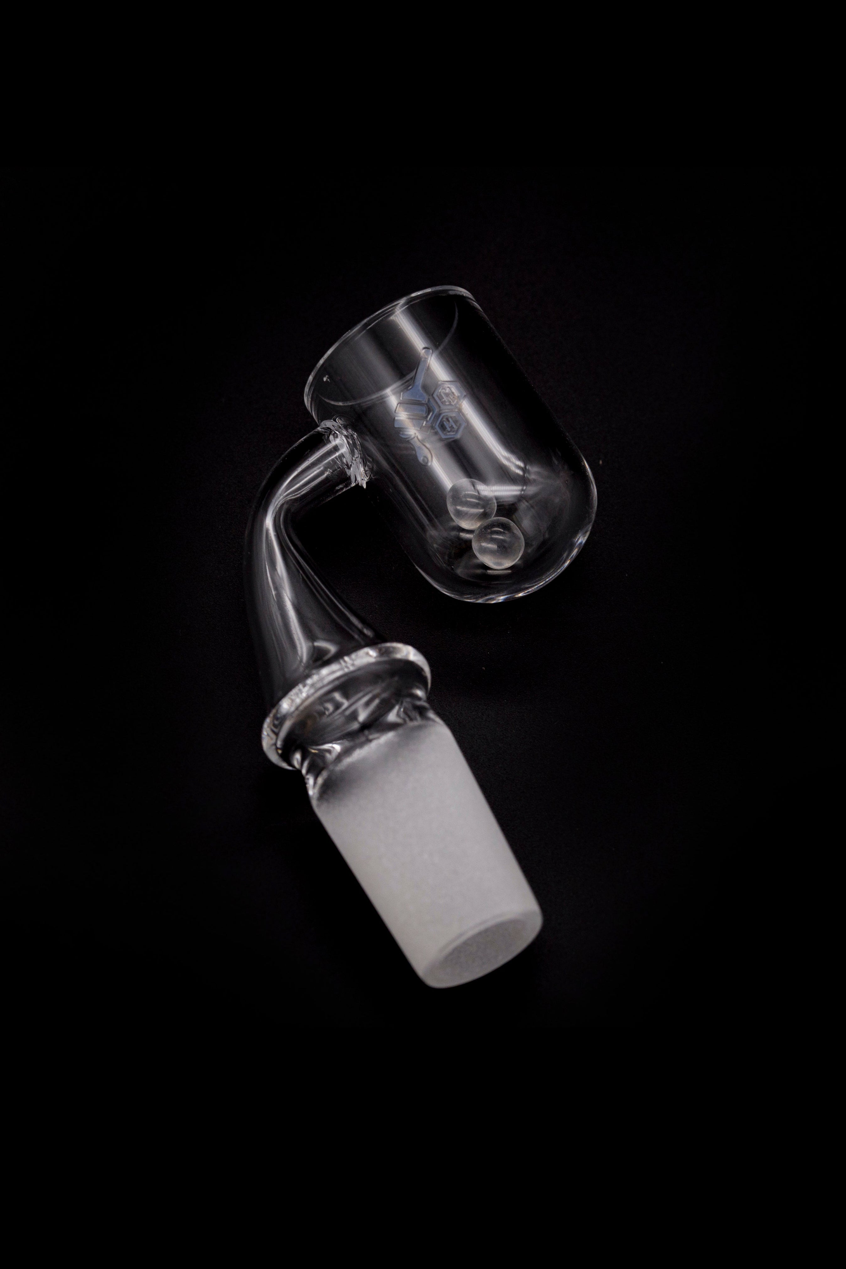 Clear glass dab rig attachment with a joint for connecting to a water pipe, isolated on a black background.