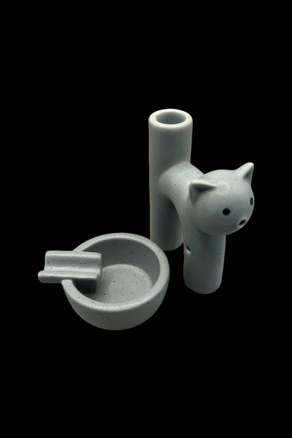 Ceramic cat-shaped bubbler and ashtray set against a black background.