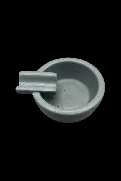 Ceramic cannabis ashtray with a built-in rest for joints or cigarettes, in a muted teal color.