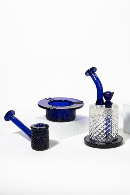 Blue and clear glass cannabis smoking accessories arranged on a white surface.