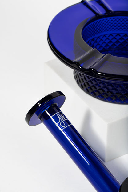 Blue glass cannabis pipe and ashtray with geometric pattern.