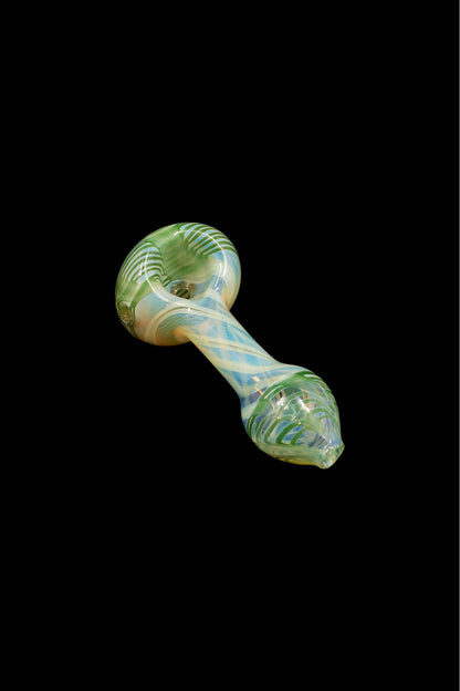 Green and cream swirled glass smoking pipe on a black background.