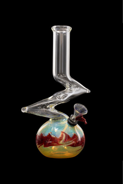 Clear glass water pipe (bong) with a rounded base featuring colorful, swirling red and teal patterns, set against a black background.
