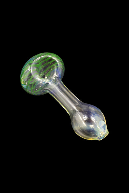 Green and clear glass pipe against a black background.