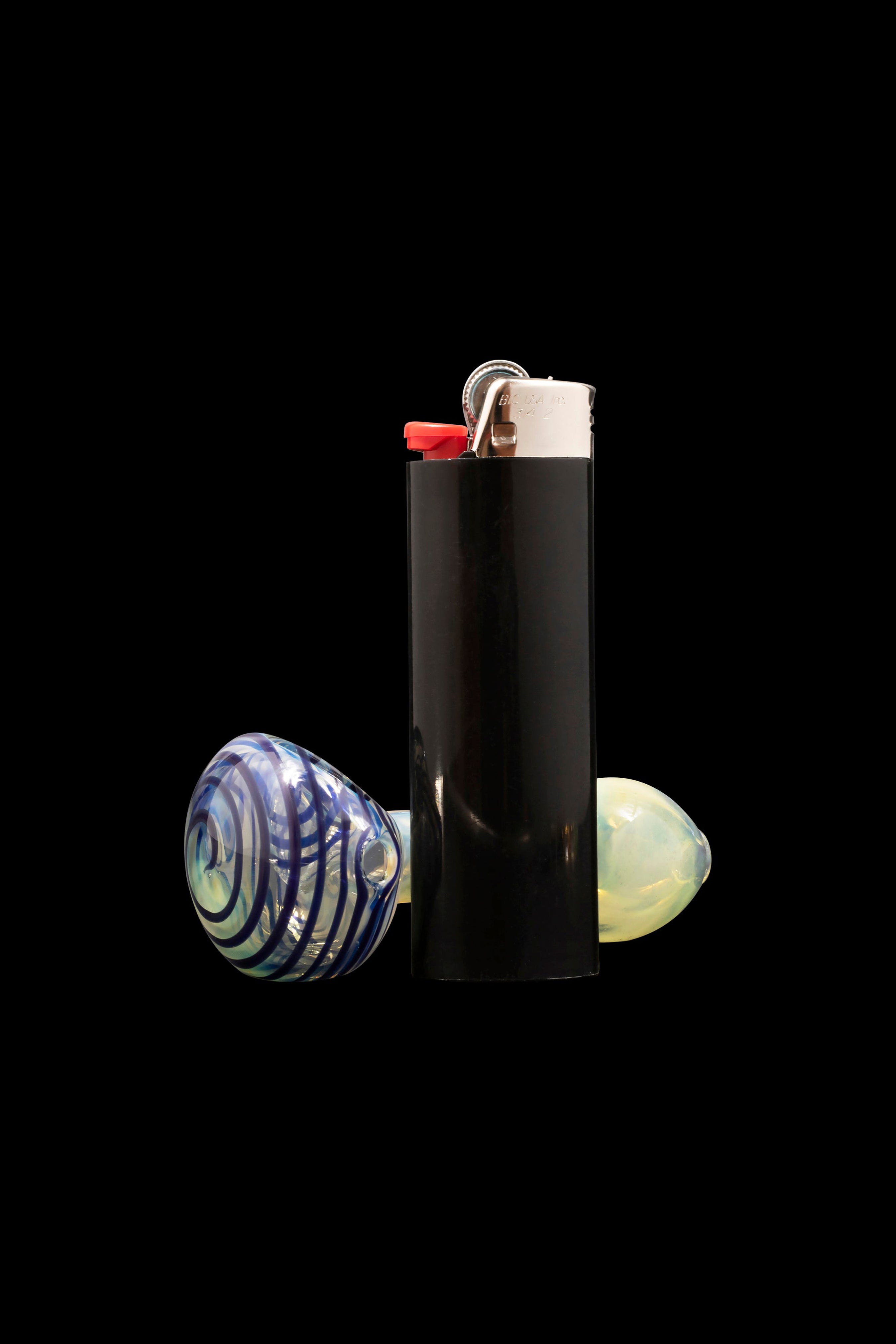 Black lighter with colorful glass marbles surrounding it on a dark background.