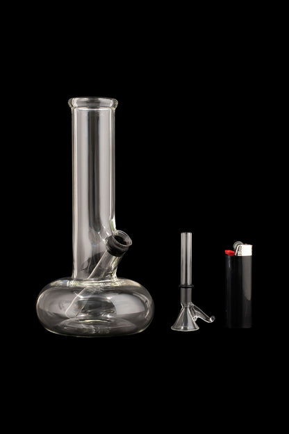 Glass bong, downstem, and lighter on a black background.