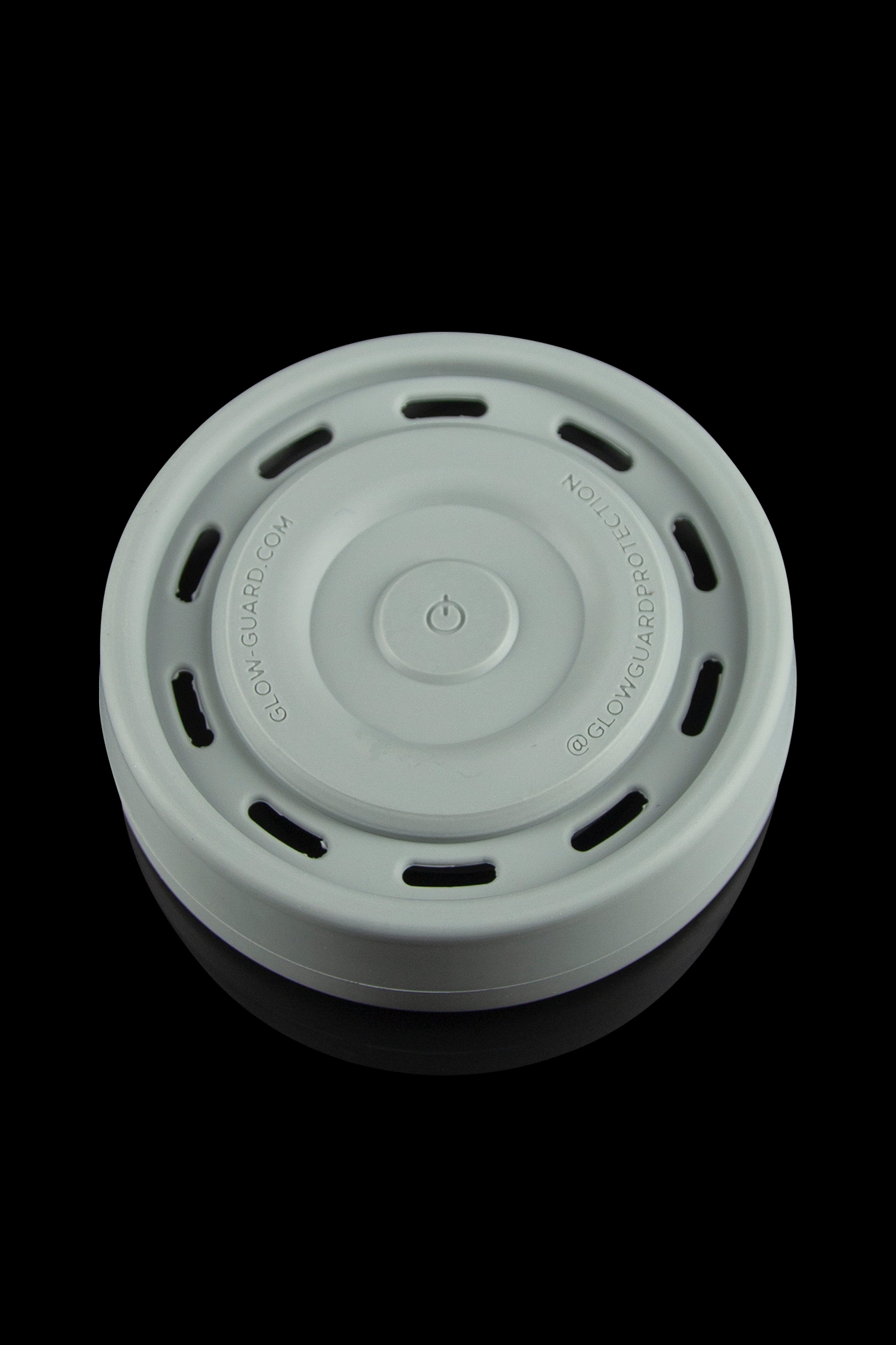Green silicone container lid with power button, likely for a cannabis storage device.