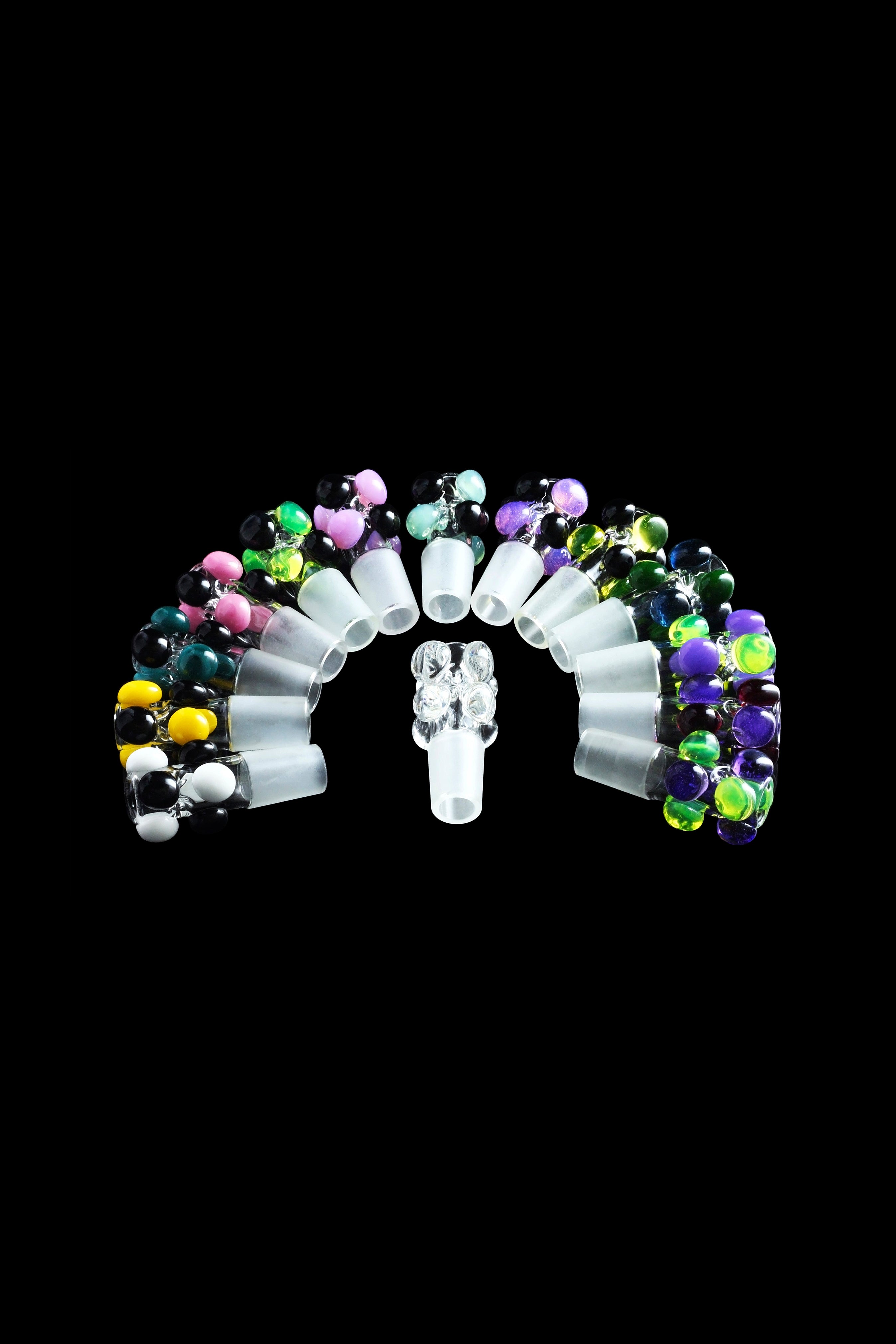 Colorful glass cannabis oil rig attachments arranged in an arc around a central dab nail.