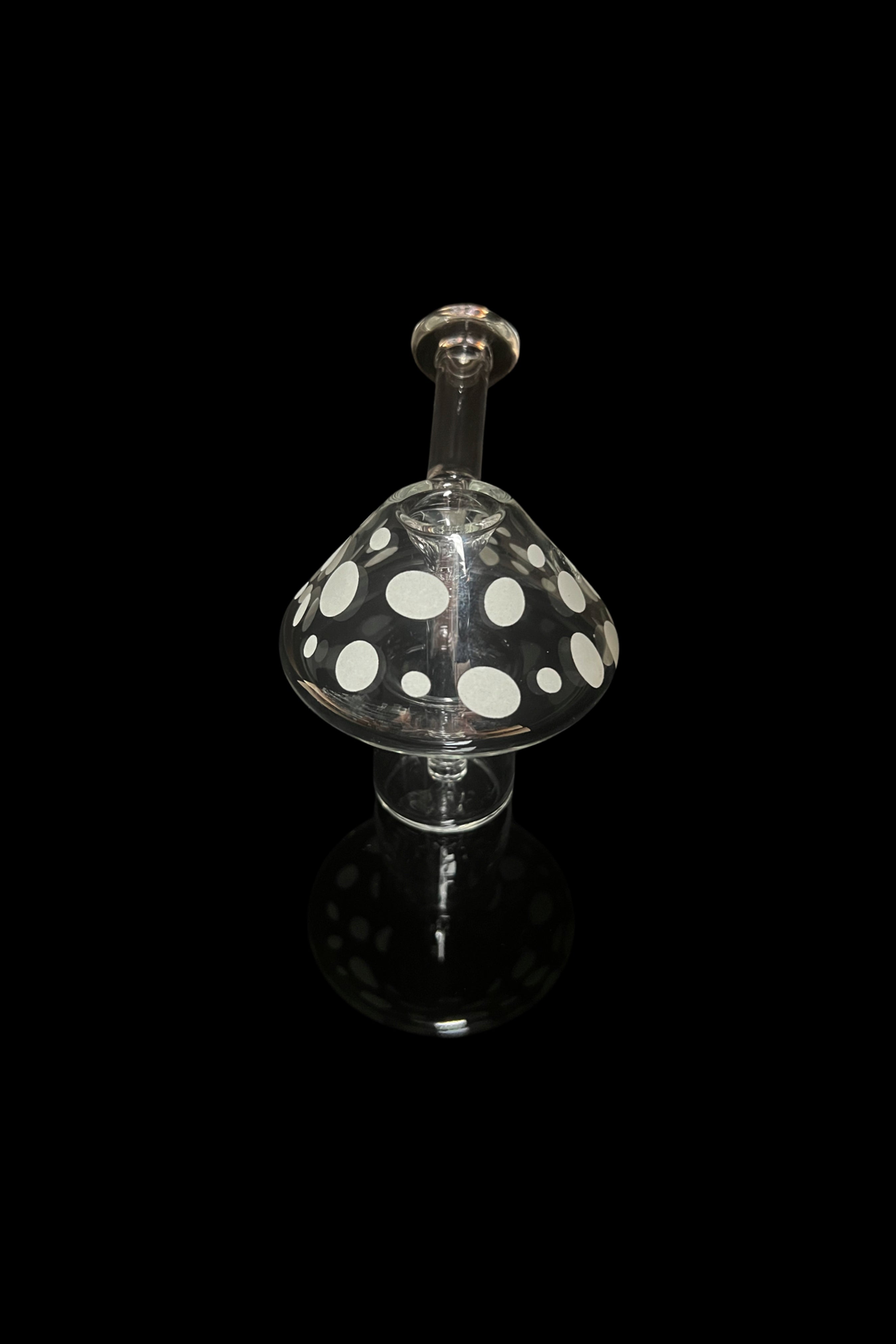 Glass mushroom-shaped oil rig with polka dots, isolated on black.