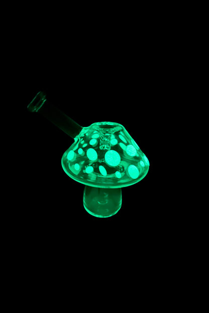 Glowing green glass mushroom-shaped oil rig for cannabis concentrates.