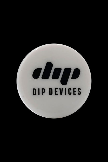 Top-down close-up of a white round lid printed with the Dip Devices Silicone Container logo against a black background