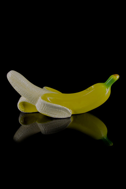 Glass banana-shaped cannabis pipe with reflective surface.