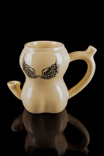 Beige ceramic bubbler with black wing design, reflecting on a glossy black surface."