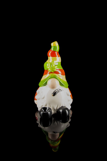 A colorful glass sculpture of a garden gnome wearing sunglasses, with cannabis leaf details, against a black background.