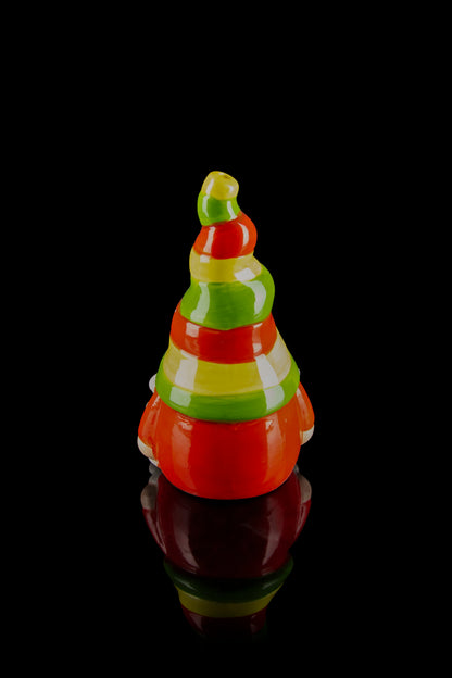 Glass cannabis water pipe shaped like a Christmas tree with red and green stripes, reflecting on a dark surface.