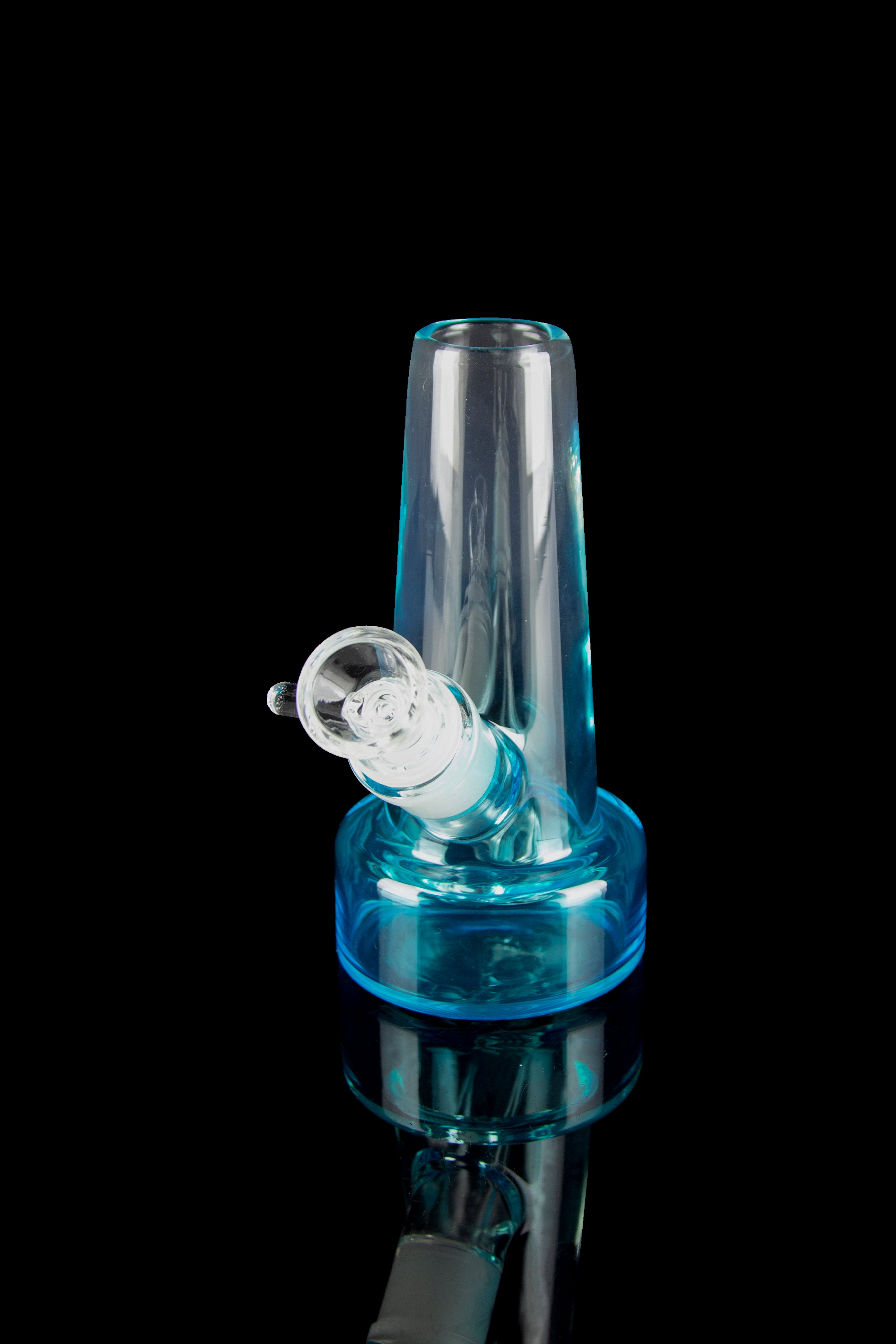 Blue glass bubbler with a clear mouthpiece, reflecting on a black surface."
