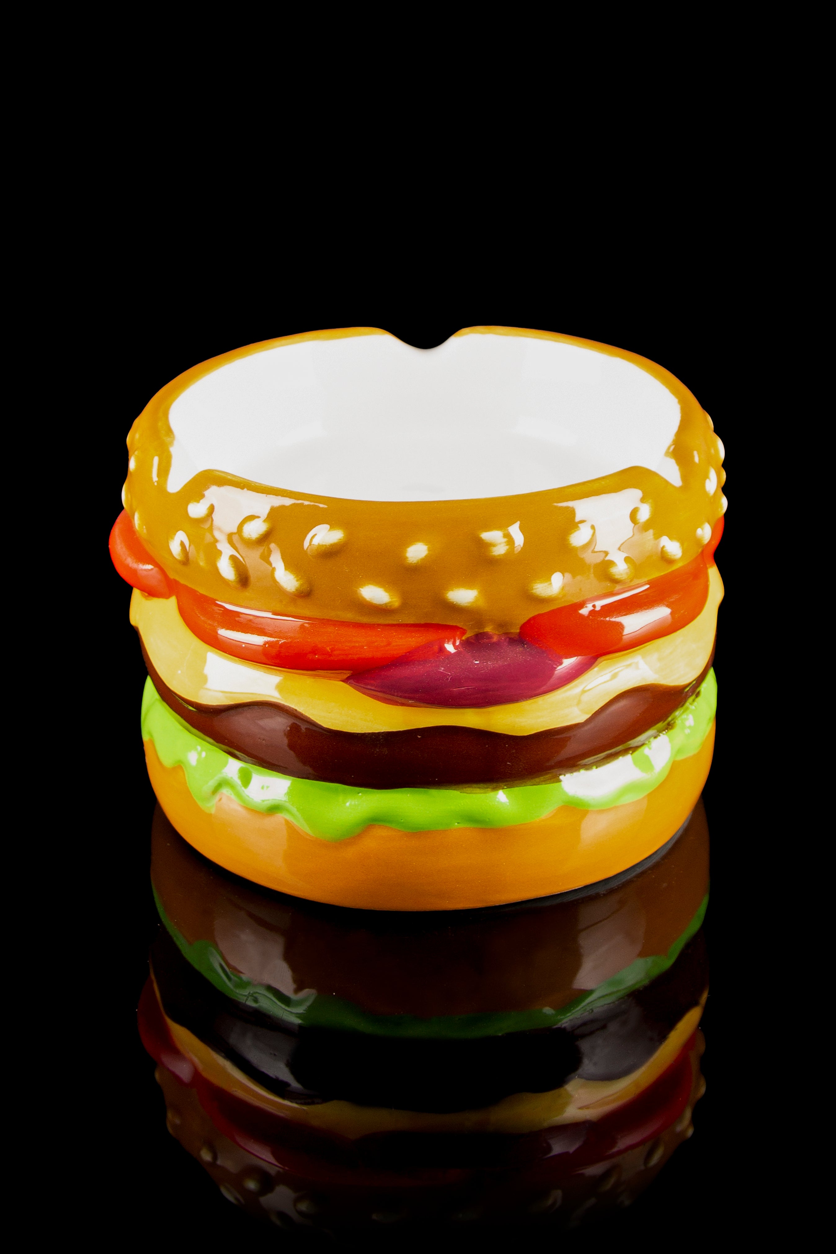 Glass pipe shaped like a colorful hamburger against a black background.
